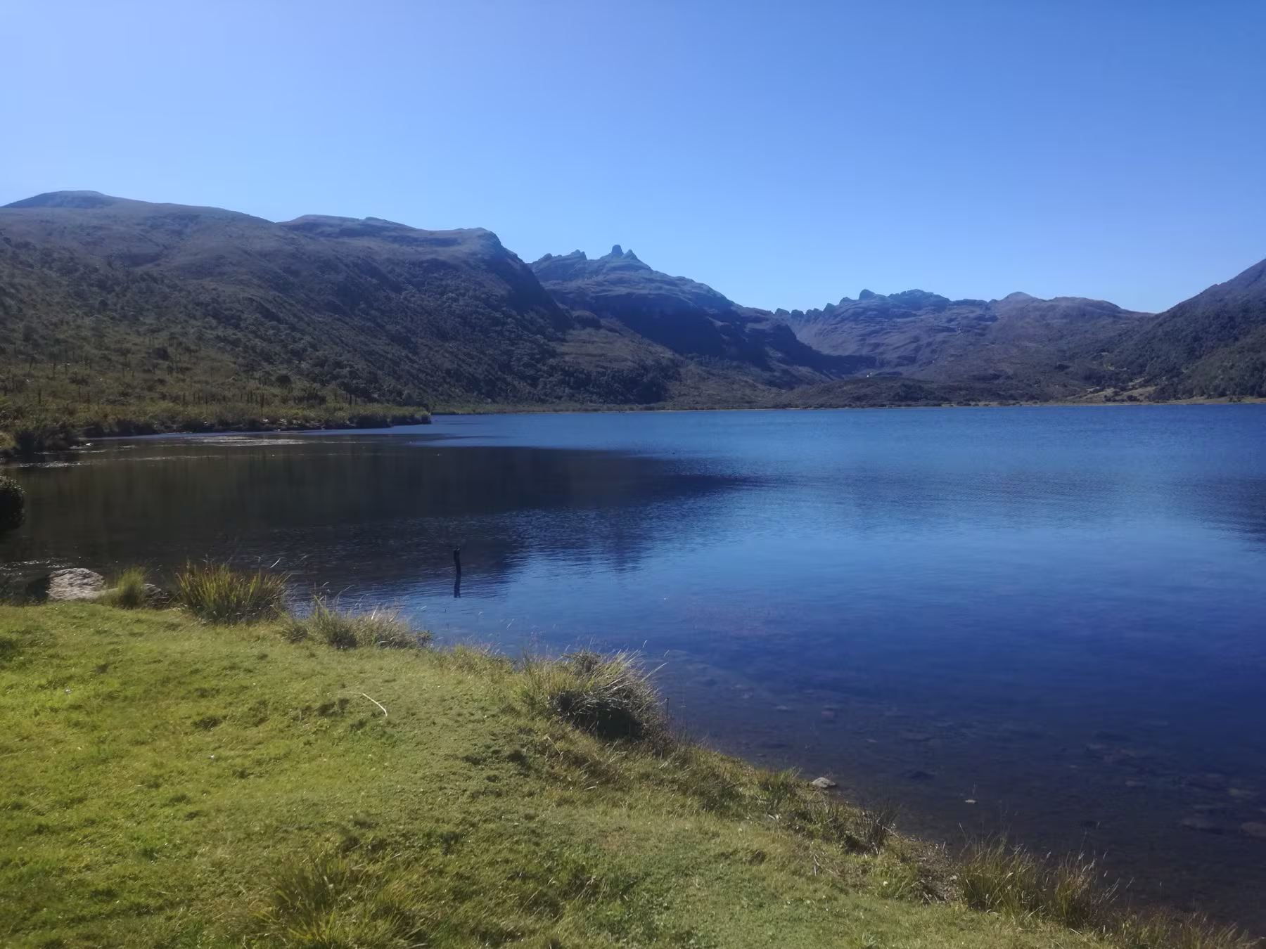Laguna de Chingaza bajo un cielo despejado, rodeada de montañas de páramo